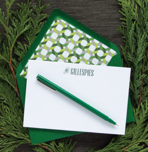 Letterpress stationery printed with a family name in green ink with dark green envelopes.